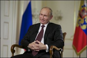 Russian President Vladimir Putin smiles during an interview with John Daniszewski, the Associated Press's Senior Managing Editor for International News during an AP interview at Putin's Novo-Ogaryovo residence outside Moscow.