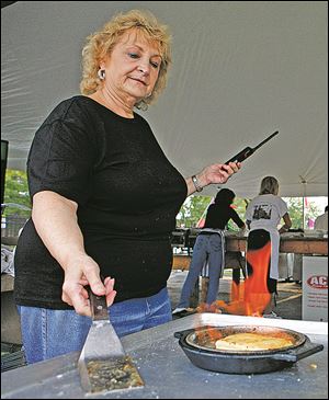 Becky Skiadas makes flaming cheese at the 41st Annual Greek American Festival at Holy Trinity Greek Orthodox Cathedral Friday, Sept. 9, 2011, in Toledo, Ohio.