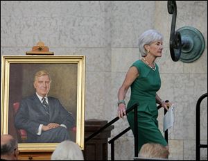 U.S. Secretary of Health and Human Services Kathleen Sebelius walks past a portrait of her father, former Ohio governor and congressman John J. Gilligan during a memorial service at the Ohio Statehouse Thursday in Columbus. Gilligan died last week at the age of 92.