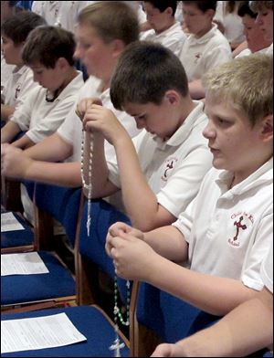 Christ the King School students hold their rosary beads during prayers for peace in Syria, as called on recently by Pope Francis.