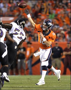 Denver Broncos quarterback Peyton Manning (18) throws under pressure from Baltimore Ravens outside linebacker Terrell Suggs (55) during the first half Thursday night in Denver.
