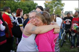 Peggy Arnold, left, hugs Ginger Smith, cousin of Terry Steinfurth, Sr., during a vigil Friday for Elaina Steinfurth at Federal and Leonard streets, the default headquarters of a volunteer-based search effort. 