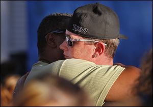 Terry Steinfurth Jr. right, gets a hug from Kyle Baker, left, during a vigil for his daughter Elaina Steinfurth.