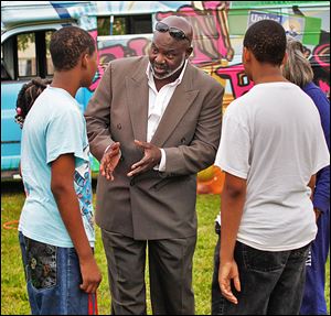 Toledo Mayor Mike Bell talks to Steven Banks, 15, during the Warren Sherman community fest. Mr. Bell said he will expand his focus to quality-of-life issues.