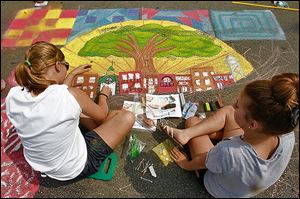 Eastwood High School art students Jenne Benier, 15, left, and Cassie VanDenk, 15, work on their team’s creation for the festival’s Chalk Walk contest. First prize is $500.