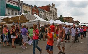 Hundreds of people mill around the artists’ booths at the Black Swamp Arts Festival in downtown Bowling Green, which continues today from 11 a.m. to 5 p.m.