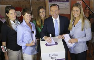 Australia's opposition leader Tony Abbott, second right, and his family from right, Bridget, Frances, wife Margaret and Louise cast their ballots today at Freshwater Surf Club in Sydney, Australia.