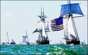The Pride of Baltimore II, right, portraying the US Brig Caledonia, leads the US Brig Niagara through a flotilla of boats during the re-enactment of the Battle of Lake Erie.