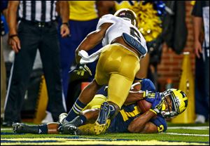 Michigan receiver Jeremy Gallon (21) scores a touchdown ahead of Notre Dame's KeiVarae Russell on a pass from Devin Gardner during the second quarter at Michigan Stadium.