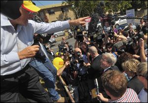 Australian Prime Minister Kevin Rudd, center, looks up at a protester, left, after casting his vote today in Brisbane, Australia.
