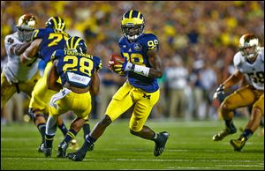 Michigan quarterback Devin Gardner rolls out during the second quarter against Notre Dame on Saturday in Ann Arbor. Gardner ran for one touchdown and passed for another. He will wear No. 98 for the remainder of the season, honoring 1940 Heisman Trophy winner Tom Harmon.