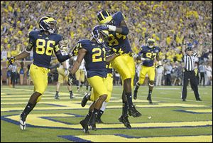 Michigan players, from left, Jehu Chesson, Jeremy Gallon, and A.J. Williams  celebrate one of Gallon’s three touchdown catches against Notre Dame. He had eight catches for 184 yards.