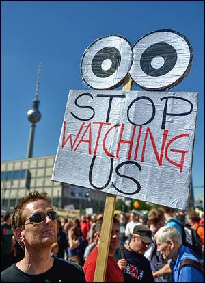 Activists  in Berlin protest on Saturday. A German weekly tells of NSA efforts to access phone data.