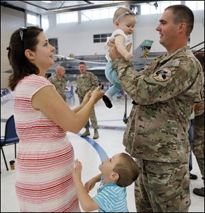 Justin Dalton, right, of the 180th Fighter Wing  with his wife Laura Dalton and their children Cyrus, 4, and Kira, 7 months, after a ceremony  honoring  180th Fighter Wing for an overseas deployment in Africa and Jordan Sunday, 09/08/13, in Toledo, Ohio.