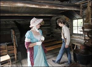 Re-enactors Kathy Dowd and her son Joseph Dowd of Toledo walk about the Navarre cabin at the Toledo Botanical Garden on Sunday as the garden honored Navarre for his pivotal role in the Battle of Lake Erie 200 years ago. 