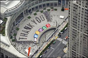 Citizens form a giant ‘thank you’ at the Tokyo Municipal Government office square Sunday after the International Olympic Committee chose the city to host the 2020 Olympics. It will be the second time the city has hosted summer games.