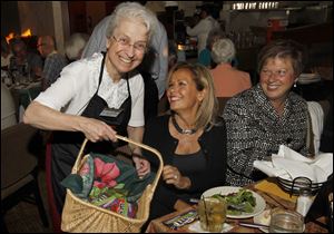 Sister Ann Carmen Barone gives M&Ms to Renee Huebner and Jill Trosin during celebrity night for Lourdes University.