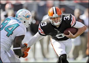 Browns quarterback Brandon Weeden is sacked by Miami's Randy Starks in the fourth quarter. Weeden was sacked six times and hammered repeatedly after several other throws.