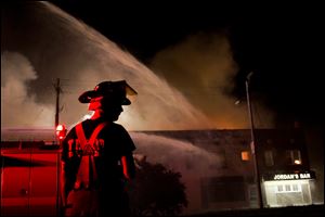Members of the Toledo Fire Department battle a fire at the corner of Front and Euclid September 10, 2013 in East Toledo.