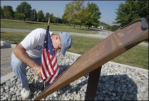 Doug Towslee places a flag with 15 stars at the memorial marker at Fort Meigs. The Masonic Order in northwest Ohio will mark its 200th anniversary of the founding of the Army Lodge No. 24.