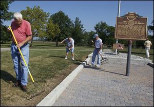 From left: Volunteers Ben Driver of Maumee,  Carl Battig of Holland, and Doug Towslee of Maumee, facing left,  work on the walkway honoring Masons who served in the War of 1812 at Fort Meigs.