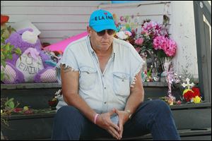 Terry Steinfurth, Sr., Elaina Steinfurth's grandfather, sits outside the Federal Street home where she went missing and where her remains were found three months later in a detached garage after numerous searches by police and family. 