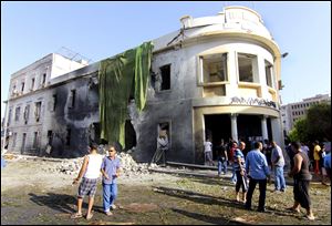 People gather to look at the site of a car bombing in Benghazi, Libya.