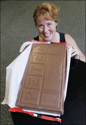 This gigantic chocolate bar held by Claudette Davis, program/activities director at the Hunt Center, will be broken up and sold in pieces during Tiedtke's Days. Tiedtke's was famous for its food, including a giant cheese wheel from which customers could buy slabs.