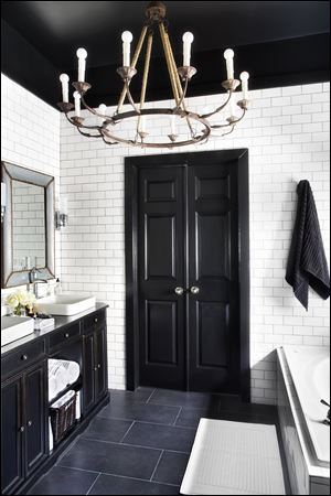 A chandelier hangs in a bathroom by designer Brian Patrick Flynn to bring a more decorative look to an otherwise task-oriented space. Chandeliers should not be limited to living rooms and dining rooms, he says .