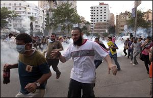 Supporters of Egypt's ousted President Mohammed Morsi run for cover from tear gas fired by police, not seen, during a protest in Cairo, Egypt, last month.