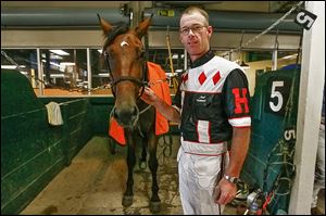 Mark Headworth, standing beside Monstro Hanover, has won more than 2,000 times at Raceway Park.