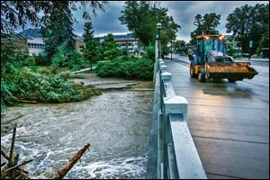 A bulldozer crosses the swollen Boulder Creek  in Boulder, Colo. Water levels have receded as intense rain abated the past two days.  In Boulder County Sunday, 234 people were unaccounted for.