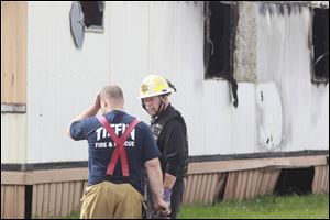 Wm. Timothy Spradlin, Chief of the Fire & Explosion Investigation Bureau with the Division of the State Fire Marshal, right, speaks with a member of Tiffin Fire & Rescue, left, during the investigation into the scene of a fire in Tiffin that killed 5 kids and one adult early this morning.