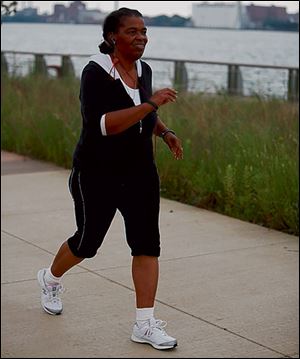 Loretta Moore walks along the Detroit riverfront. Moore lost 62 pounds during a two-year period by walking and changing her eating habits.