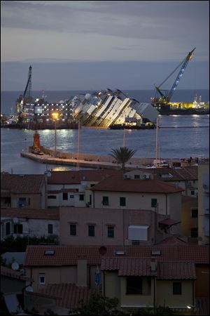 The Costa Concordia ship lies on its side today a maritime salvage operation wrestles the hull off the Italian reef where the cruise ship has been stuck since January 2012. 