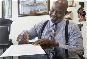 Toledo mayor Mike Bell, left, and City Councilman D. Michael Collins sign the Clean Campaign Pledge proposed by The Blade.