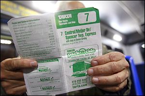 A Route 7 rider examines a schedule. If TARTA’s Spencer Township service ends, employees at an industrial park, patients at the Western Lucas County Clinic, and people who use a neighborhood center would be among those losing their ride. 