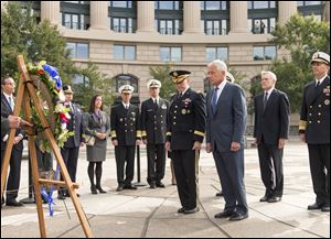 Defense Secretary Chuck Hagel, center right, and Joint Chiefs Chairman Gen. Martin Dempsey, center left, lead a delegation at the Navy Memorial in Washington to remember the victims of Monday's deadly shooting at the Washington Navy Yard.