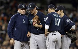 Seattle Mariners manager Eric Wedge, left, pulls starting pitcher Brandon Maurer in the sixth inning.
