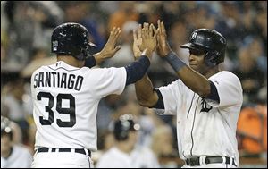 Detroit Tigers' Torii Hunter, right, celebrates with Ramon Santiago (39) after they scored on a Prince Fielder single in the fifth inning Friday in Detroit.