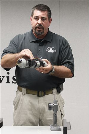 ATF Explosives Enforcement Officer Michael Eggleston demonstrates the workings of what authorities termed a ‘basic representative’ of the bomb used against the Chappells in Monroe two years ago. The bomber had to be in sight of the Chappell vehicle and no more than a half-mile away from it, Mr. Eggleston said.