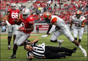 Ohio State TB Jordan Hall takes out an official on his way to scoring a touchdown against  Florida A&M SS Jonathan Pillow (19) during the second quarter.