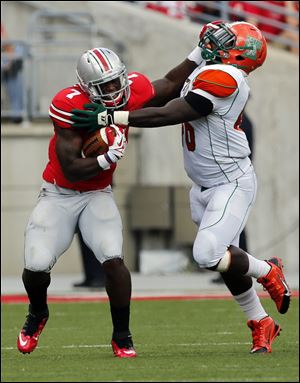 Ohio State TB Rod Smith (7) stiff arms  Florida A&M Colby Blanton (36) during the second quarter.