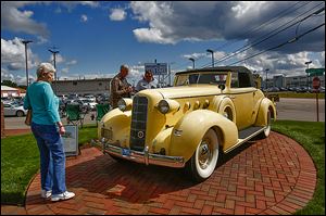 Noreen Greathouse of South Toledo takes a look at a 1935 LaSalle owned by Richard Zapala of Haslett, Mich.