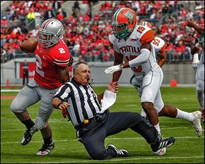 Ohio State's Jordan Hall knocks down an official on his way to to the end zone as Florida A&M's Jonathan Pillow gives chase. The Buckeyes built a 55-0 halftime lead.