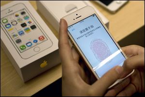 A customer configures the fingerprint scanner technology built into iPhone 5S at an Apple store in Wangfujing shopping district in Beijing.