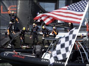 Oracle Team USA celebrates after beating Emirates Team New Zealand during the 16th race of the America's Cup sailing event today in San Francisco.
