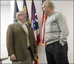 D. Michael Collins, left, speaks with Bruce Baumhower, right, president of Local 12, after accepting the UAW's endorsement for mayor.