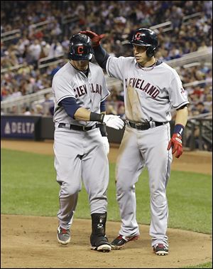 The Indians' Ryan Raburn, right, high-fives Mike Avilies after Raburn scored on an error by Minnesota's Chris Colabello at first base during the fourth inning of Thursday’s game.
