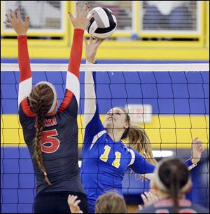 St. Ursula's Hannah Engler, right, attempts to spike the ball against Central Catholic's Sierra Sedlak on Thursday. The Arrows beat the Eagles in three games.